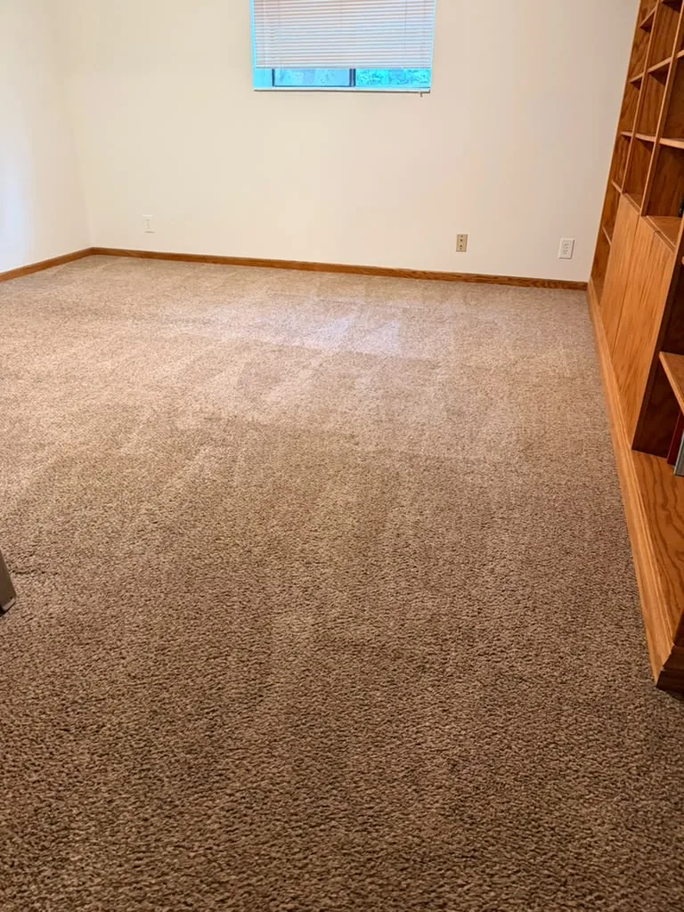 Empty bedroom with freshly vacuumed carpet after a move-out cleaning