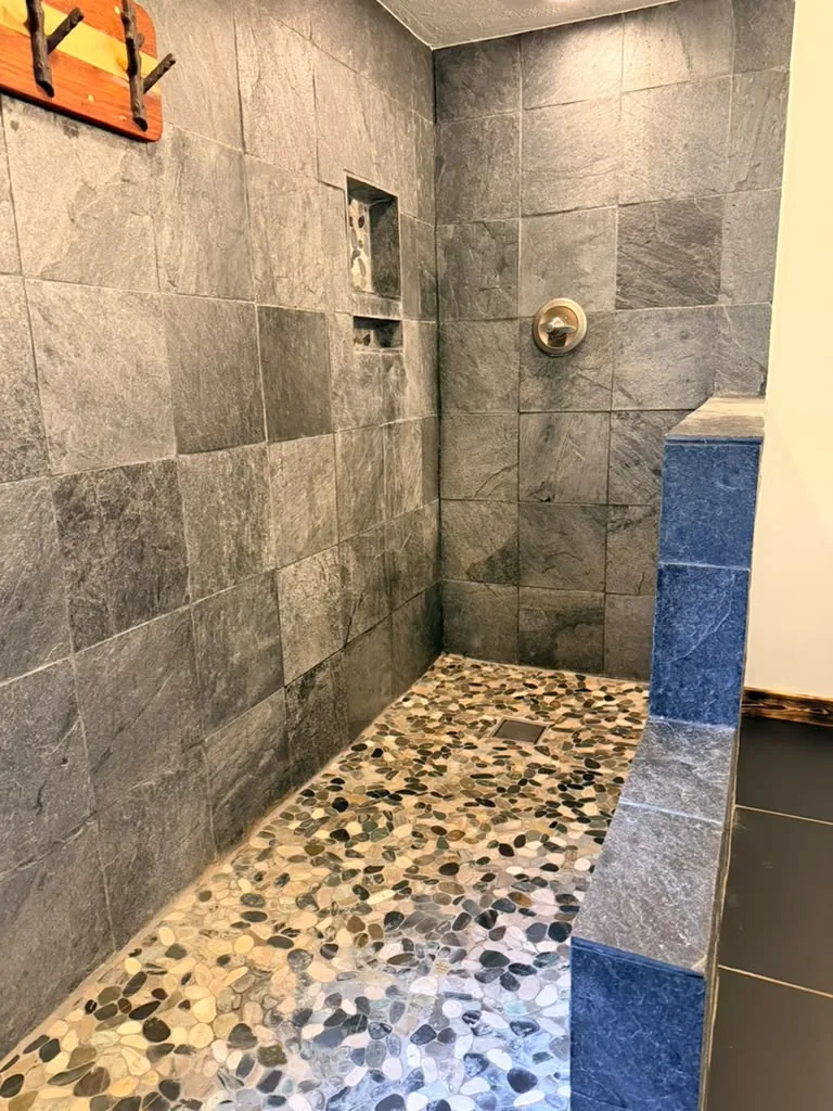 Clean stone-tile shower with sparkling glass
