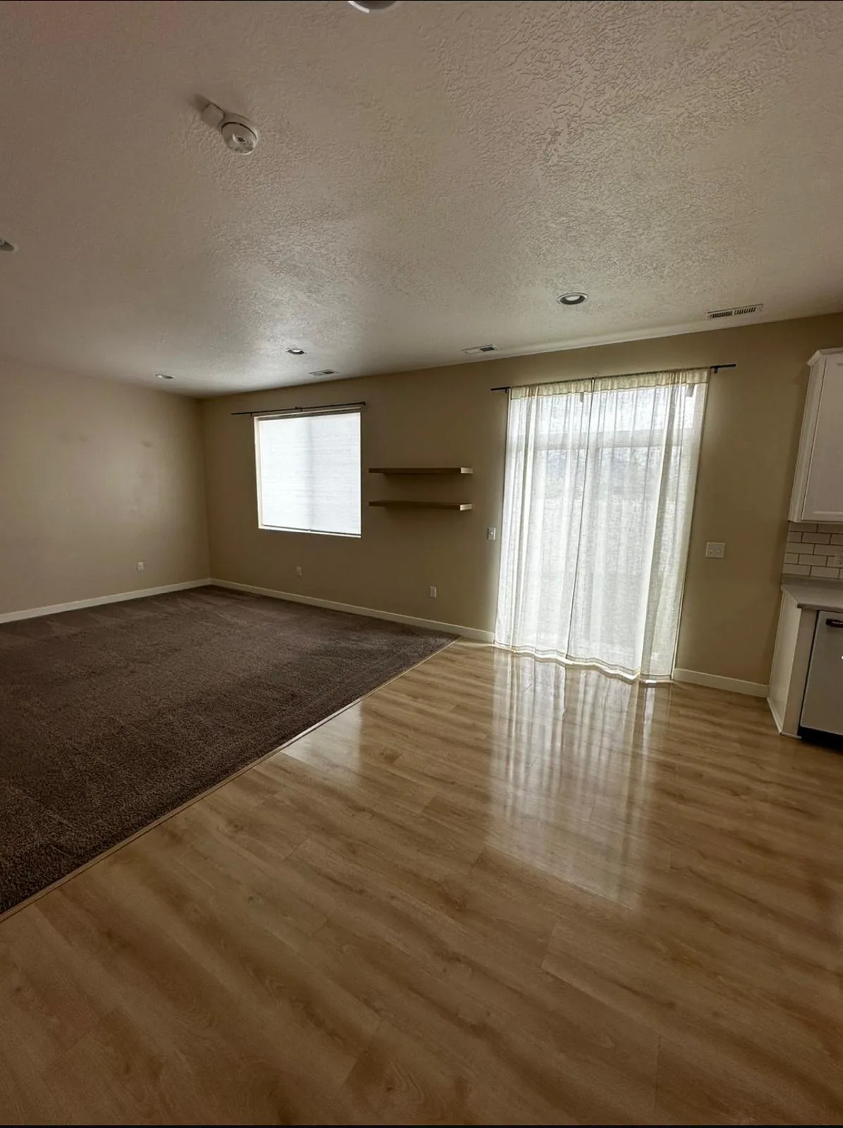 Empty living room with clean carpet and shining wood floors, ready for move-in